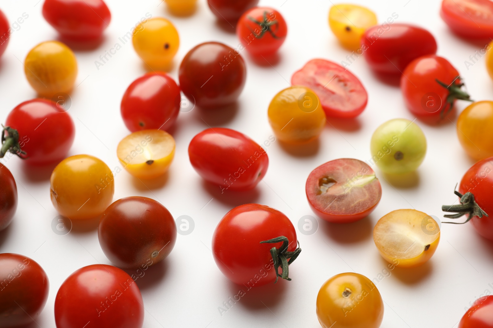 Photo of Different ripe tomatoes on white table, closeup