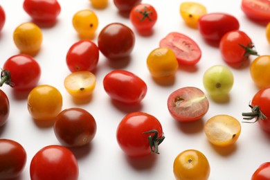 Photo of Different ripe tomatoes on white table, closeup
