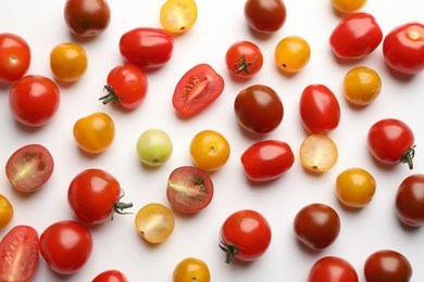 Photo of Different ripe tomatoes on white table, flat lay