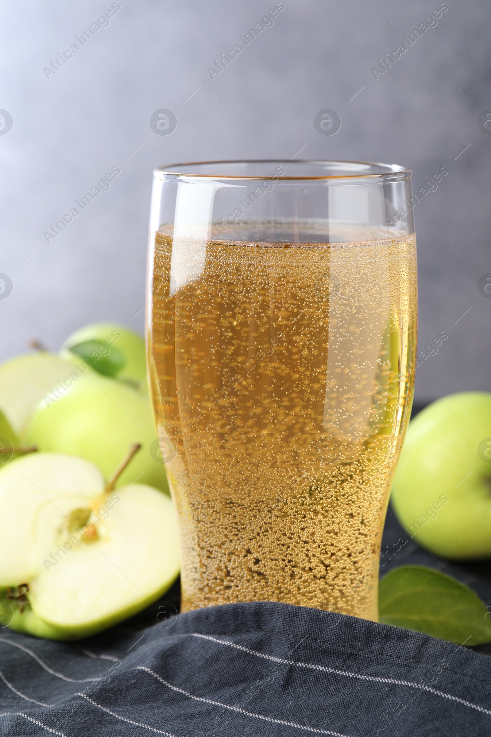 Fresh cider in glass and apples on table, closeup Photo of Fresh cider in glass and apples on table, closeup
