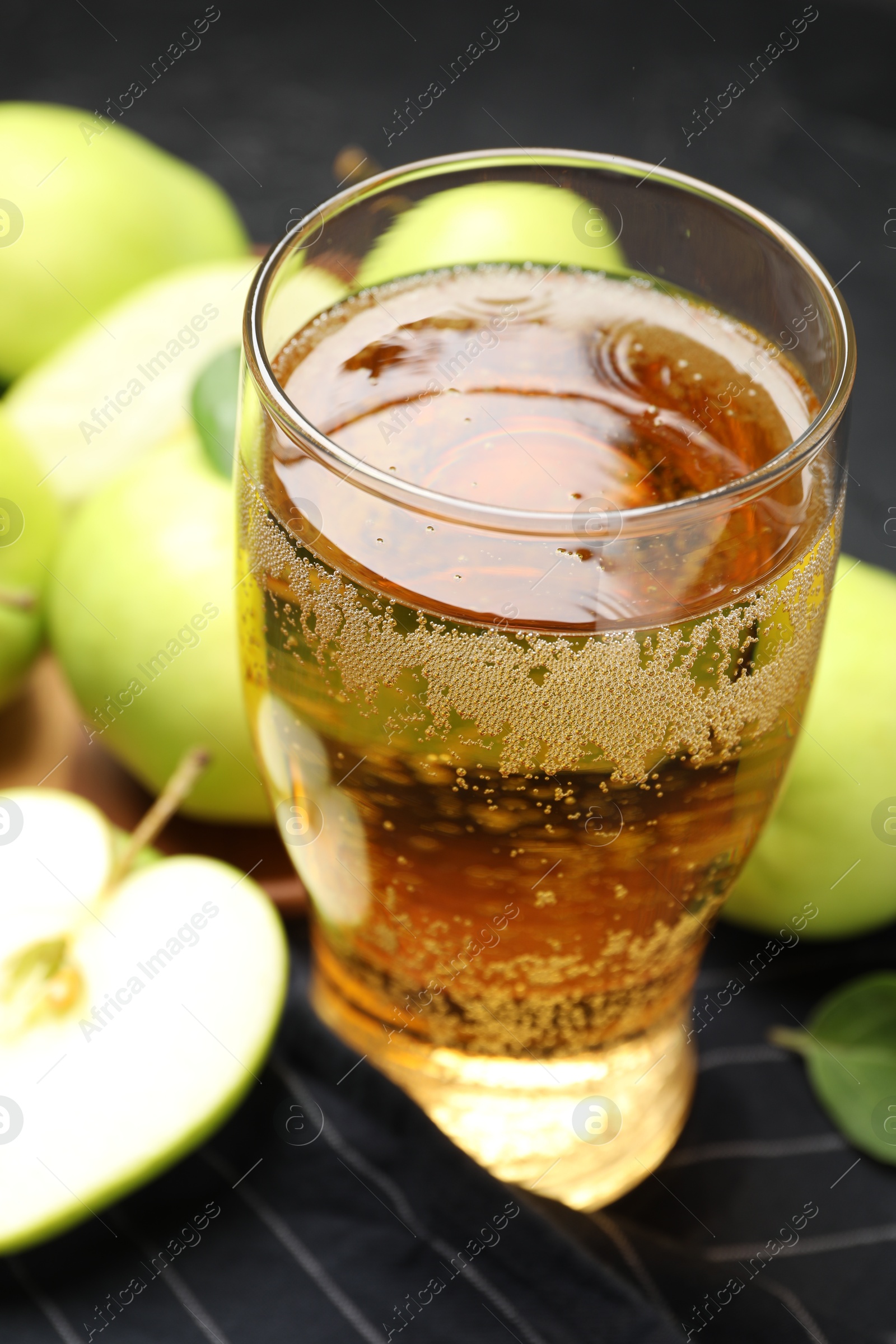 Fresh cider in glass and apples on table, closeup Photo of Fresh cider in glass and apples on table, closeup