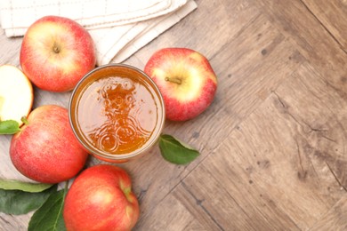 Photo of Fresh cider in glass and apples on wooden table, flat lay. Space for text