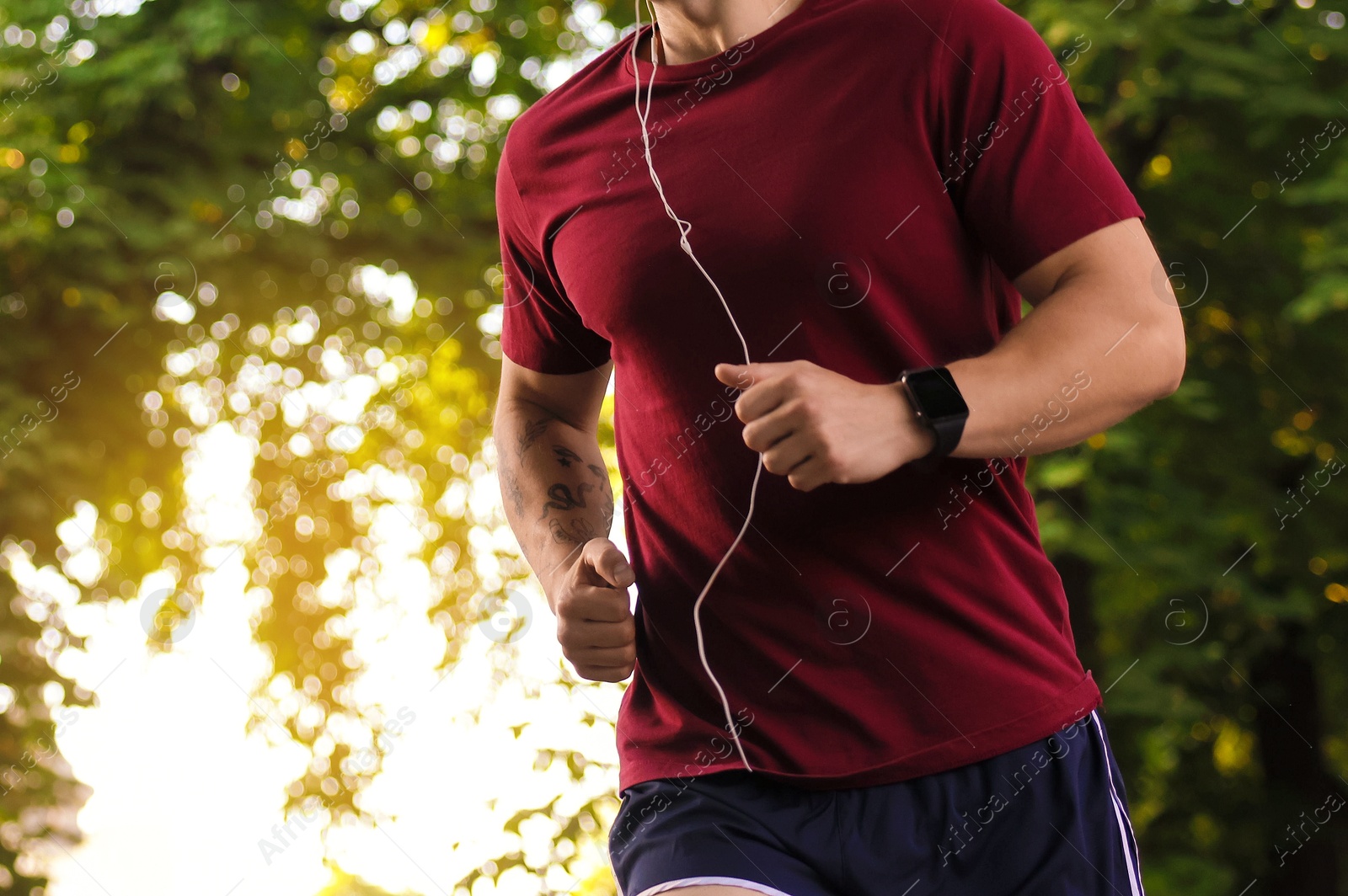 Athletic young man in sportswear running outdoors, closeup Photo of Athletic young man in sportswear running outdoors, closeup