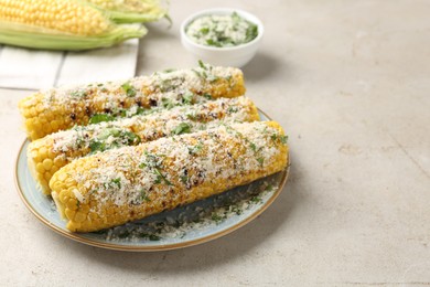 Photo of Tasty grilled corncobs with parsley and cheese on light table