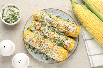 Photo of Tasty grilled corncobs with parsley and cheese on light table, flat lay