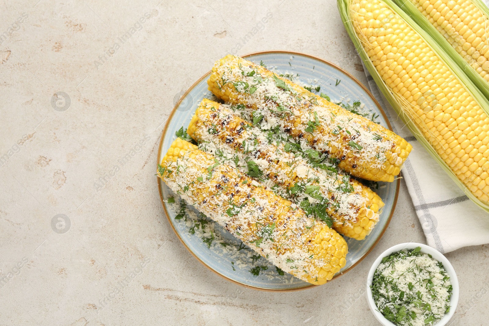 Photo of Tasty grilled corncobs with parsley and cheese on light table, flat lay. Space for text