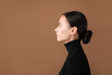 Photo of Portrait of beautiful woman on brown background. Space for text