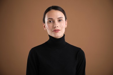 Photo of Portrait of beautiful woman on brown background