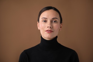 Photo of Portrait of beautiful woman on brown background