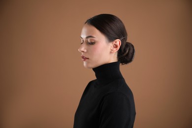 Photo of Portrait of beautiful woman on brown background