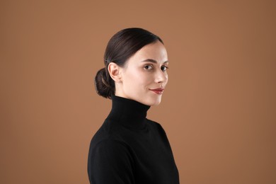 Photo of Portrait of beautiful woman on brown background