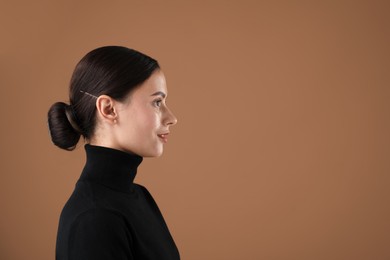 Photo of Portrait of beautiful woman on brown background. Space for text