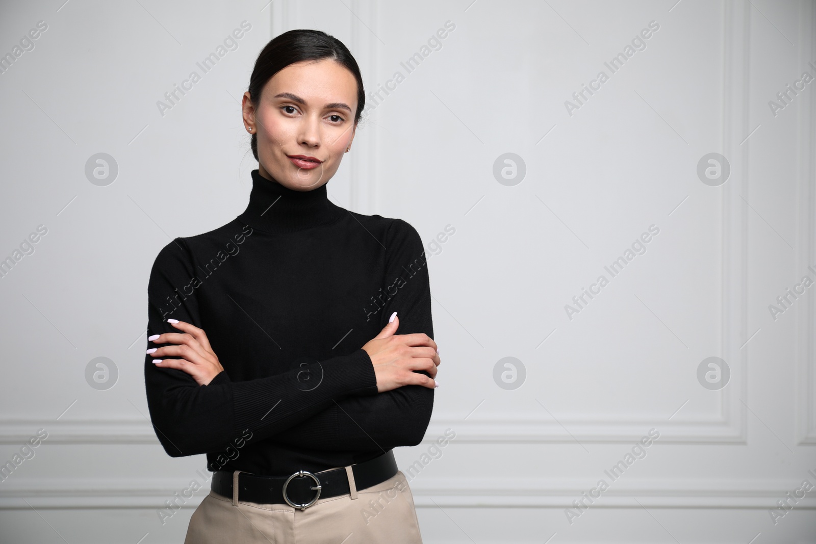Photo of Portrait of beautiful woman near white wall. Space for text