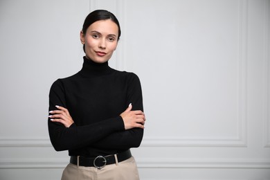 Photo of Portrait of beautiful woman near white wall. Space for text