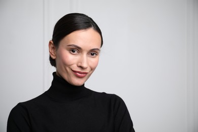 Photo of Portrait of beautiful woman near white wall. Space for text
