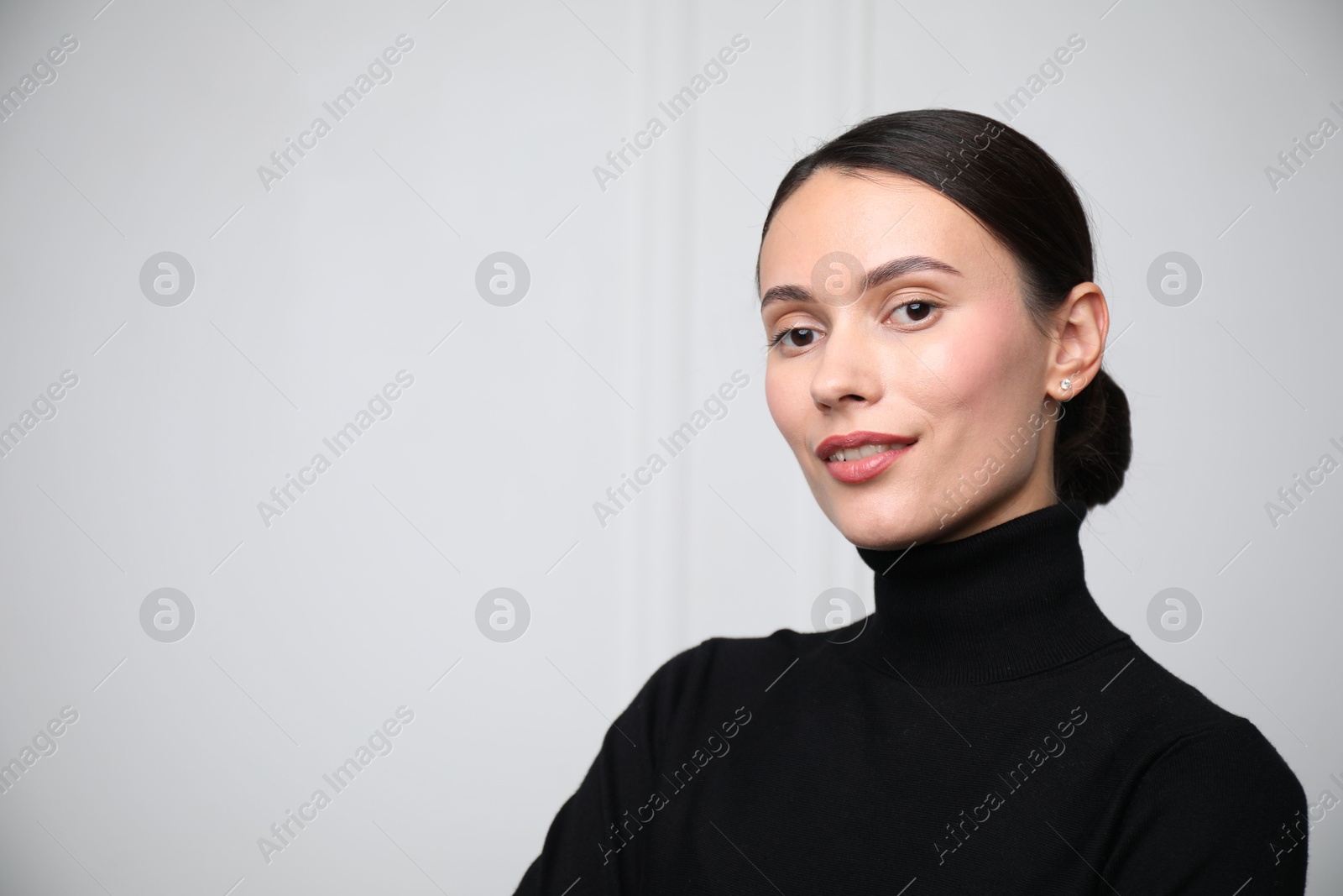 Photo of Portrait of beautiful woman near white wall. Space for text