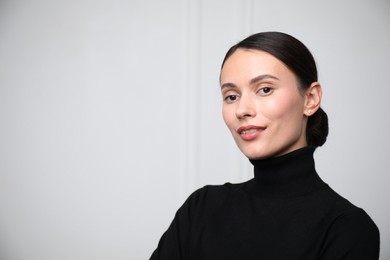 Photo of Portrait of beautiful woman near white wall. Space for text