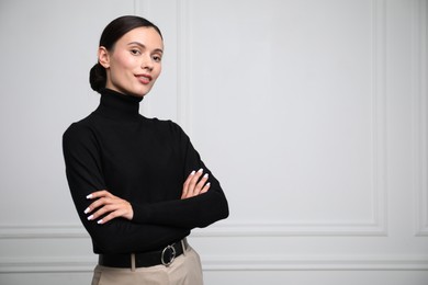 Photo of Portrait of beautiful woman near white wall. Space for text