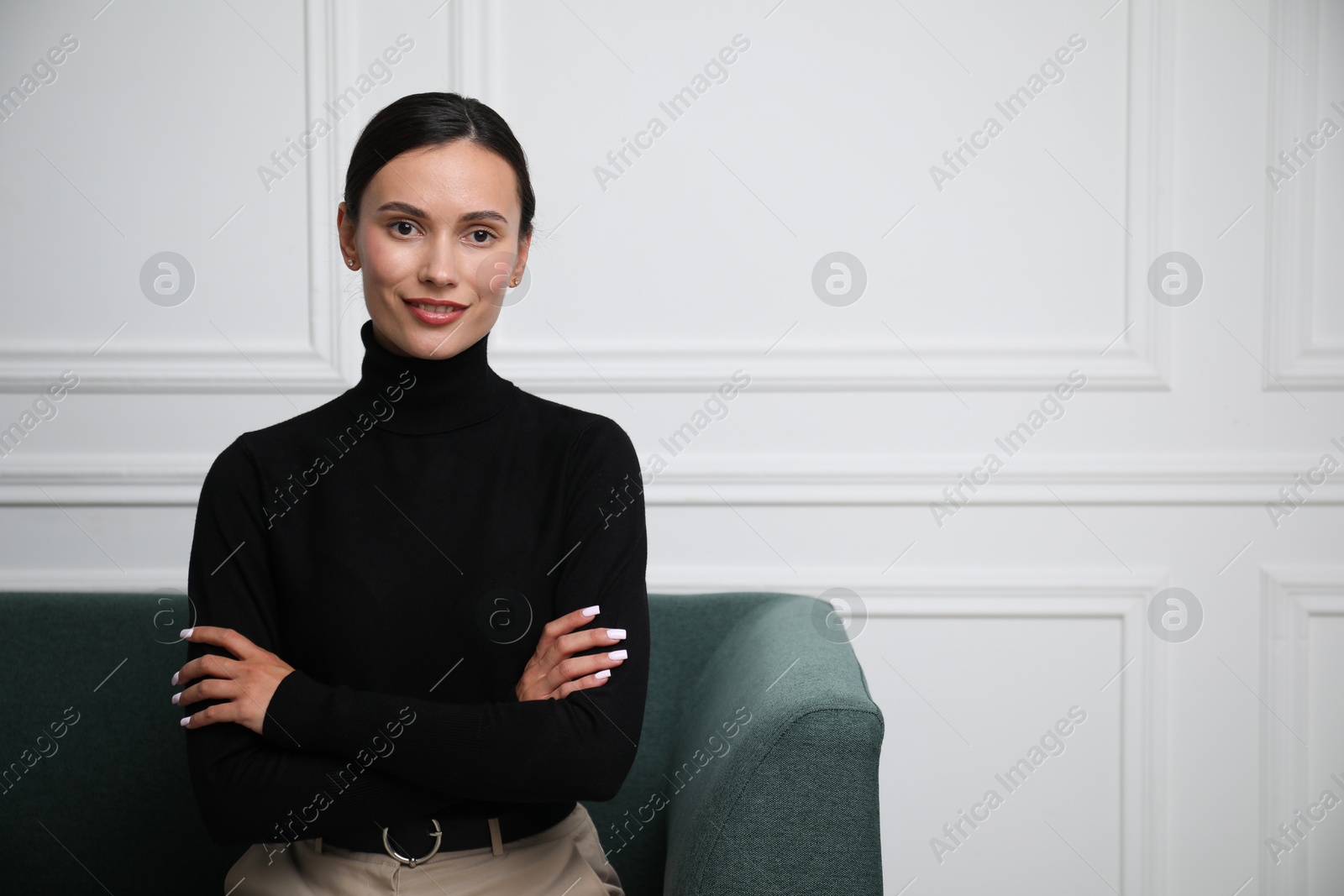 Photo of Beautiful woman on sofa near white wall. Space for text