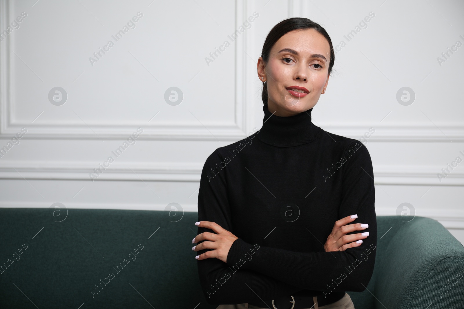 Photo of Beautiful woman on sofa near white wall. Space for text
