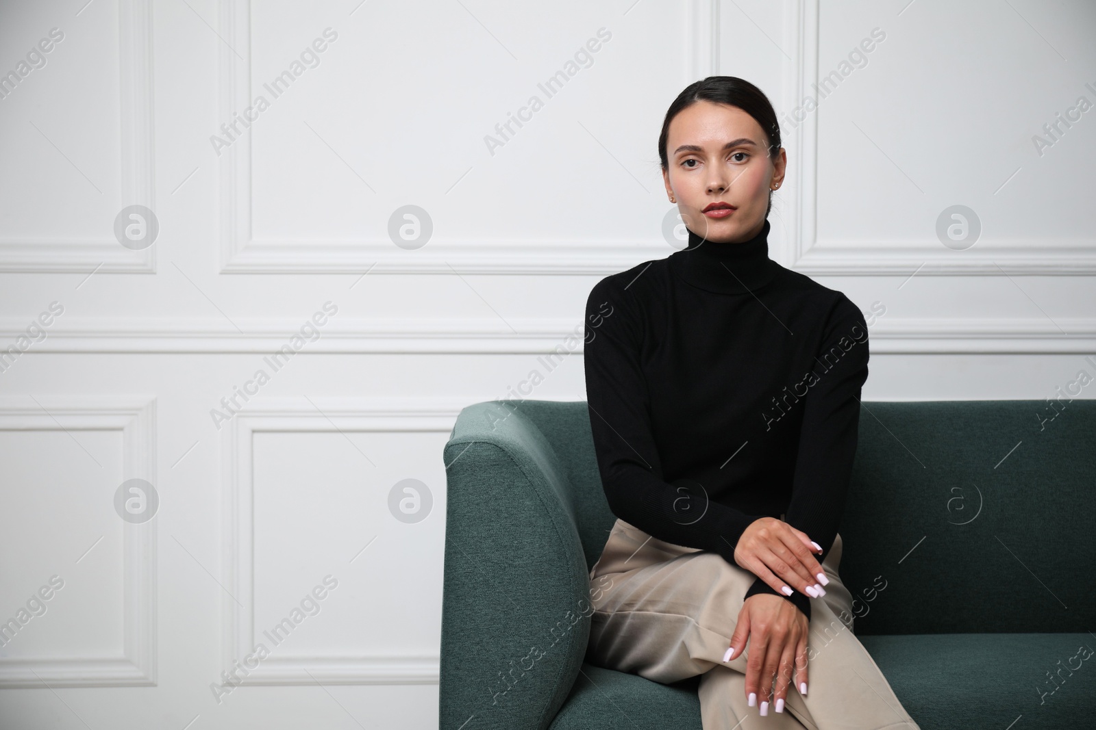 Photo of Beautiful woman on sofa near white wall. Space for text