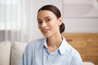 Photo of Elegant woman sitting on sofa at home