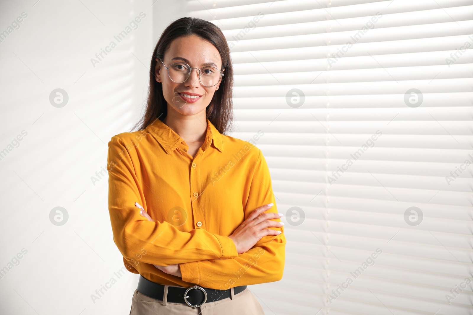 Photo of Beautiful young woman near white wall indoors. Space for text
