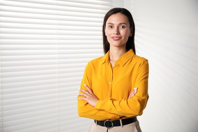 Photo of Beautiful young woman near white wall indoors. Space for text