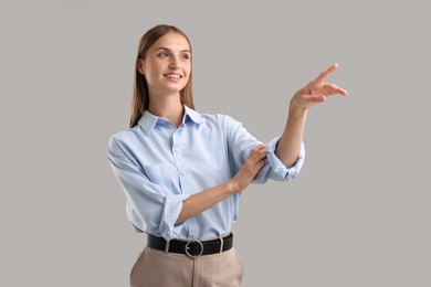 Photo of Beautiful woman pointing at something on light background