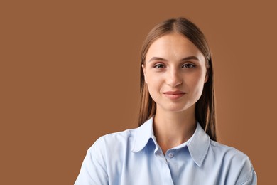 Photo of Portrait of beautiful woman on brown background. Space for text
