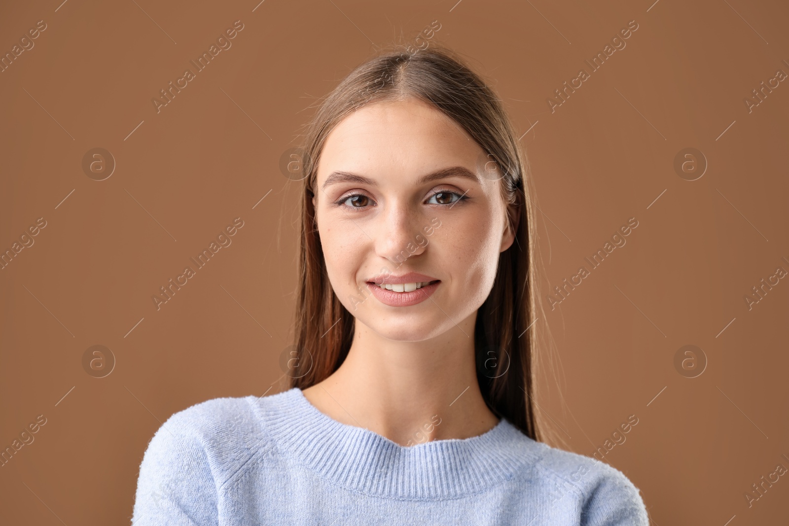 Portrait of beautiful woman on brown background Photo of Portrait of beautiful woman on brown background