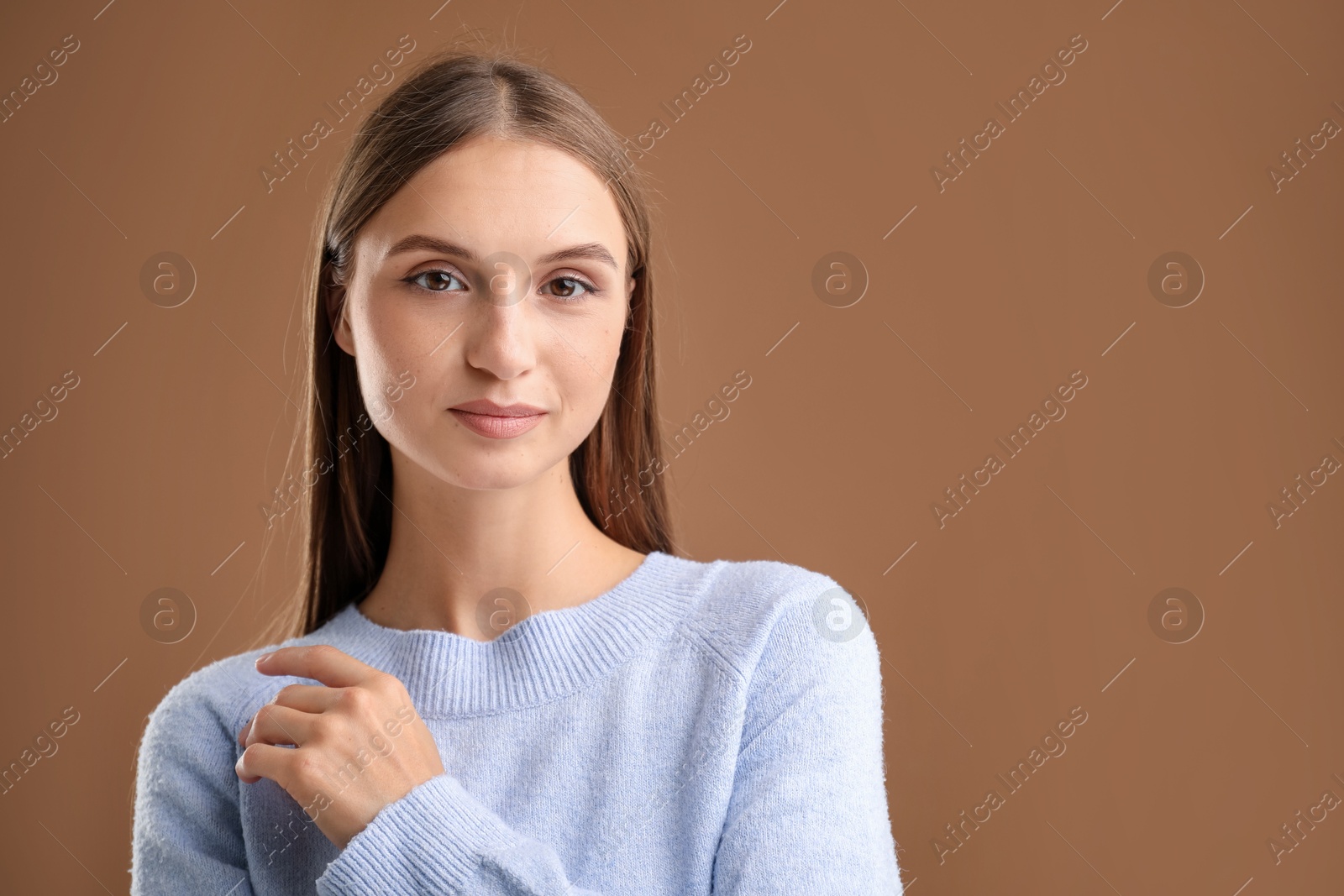 Photo of Portrait of beautiful woman on brown background. Space for text