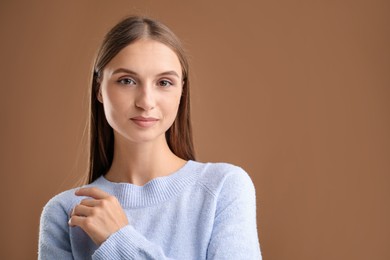 Photo of Portrait of beautiful woman on brown background. Space for text
