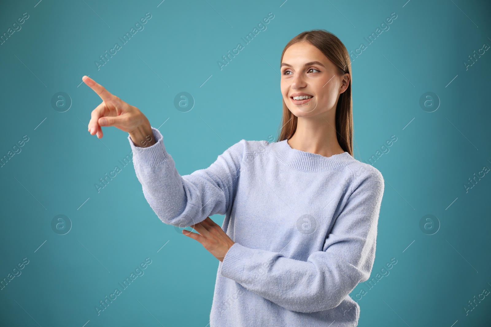 Photo of Beautiful woman pointing at something on blue background