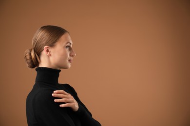 Photo of Portrait of beautiful woman on brown background. Space for text