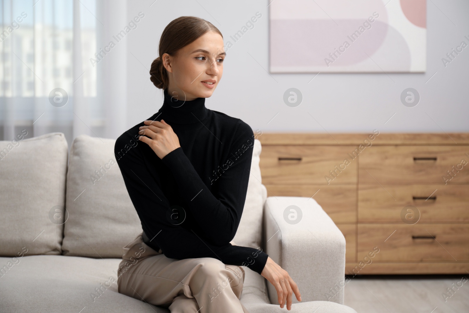 Photo of Elegant woman sitting on sofa at home