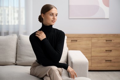 Photo of Elegant woman sitting on sofa at home