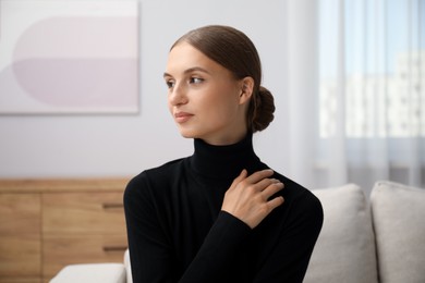 Photo of Elegant woman sitting on sofa at home