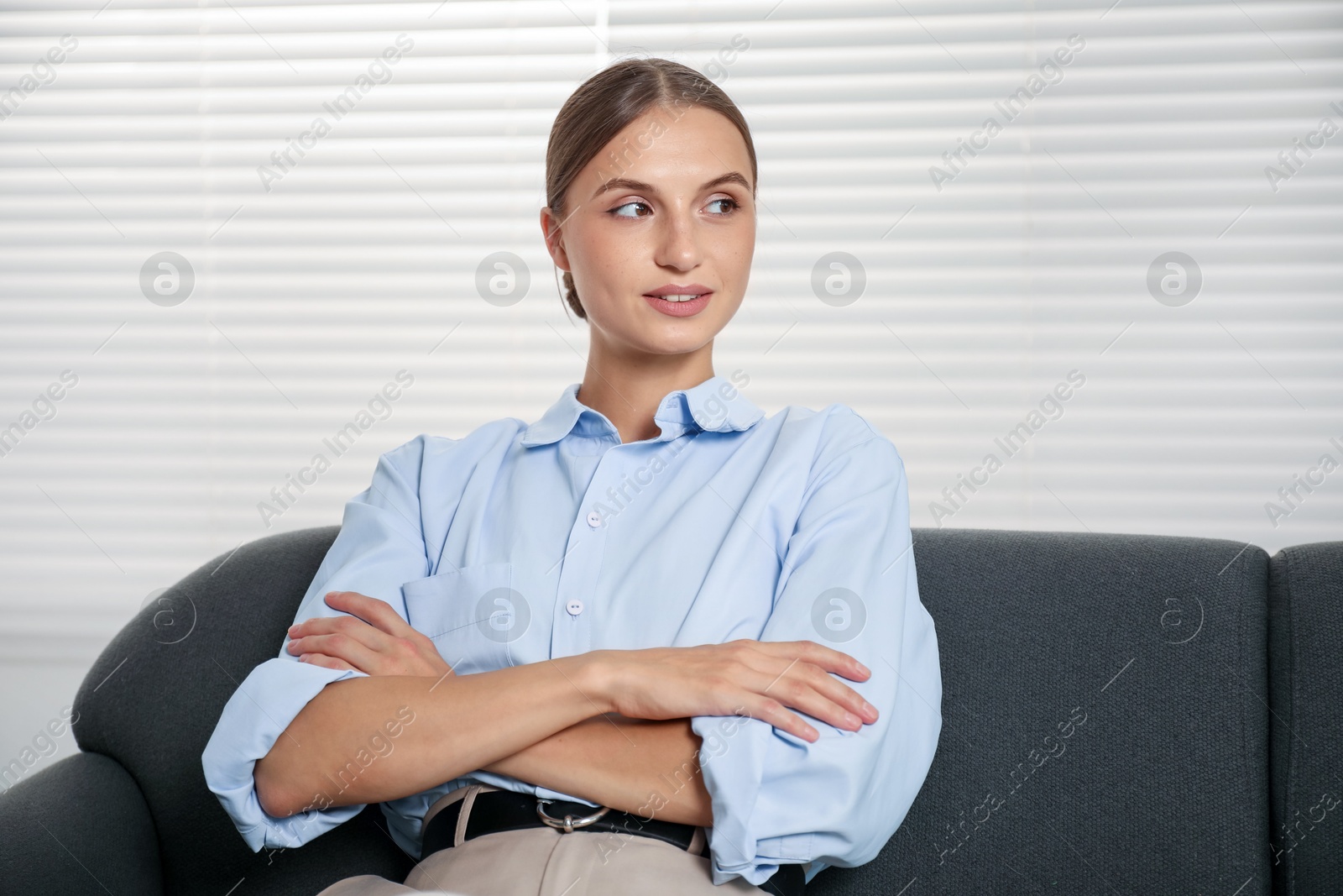Photo of Beautiful businesswoman sitting on sofa at home