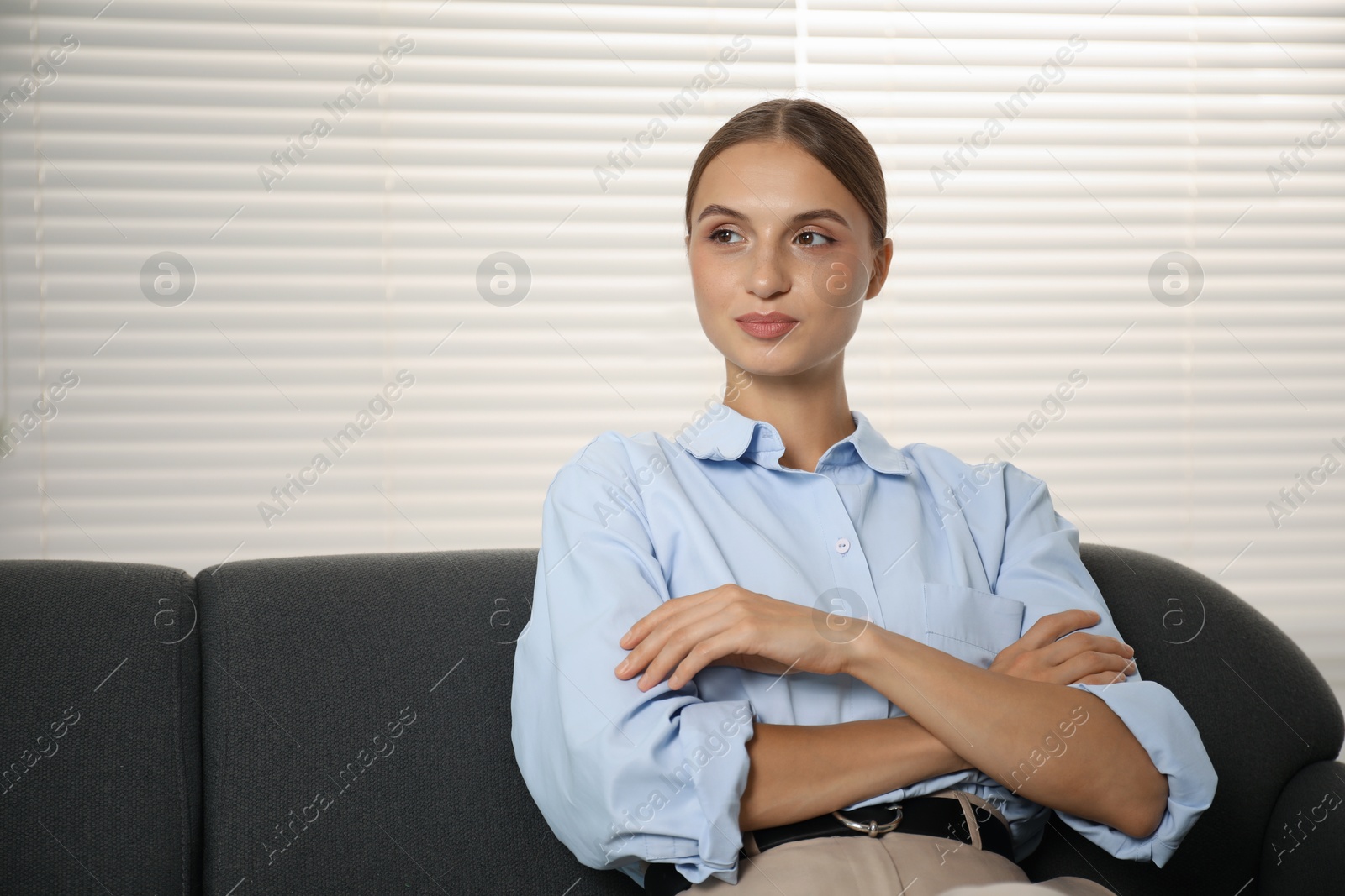 Photo of Beautiful businesswoman sitting on sofa at home. Space for text