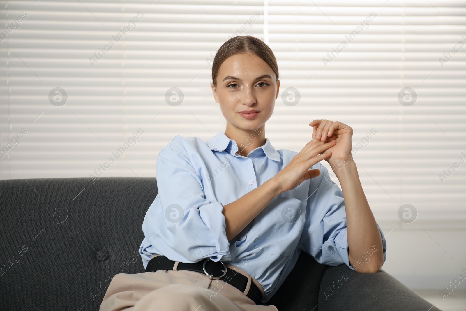 Photo of Beautiful businesswoman sitting on sofa at home