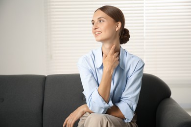 Photo of Beautiful businesswoman sitting on sofa at home. Space for text