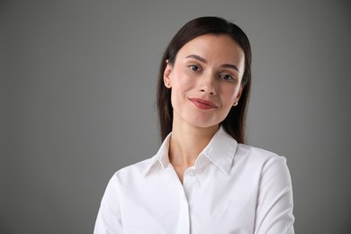 Photo of Portrait of confident businesswoman on grey background. Space for text