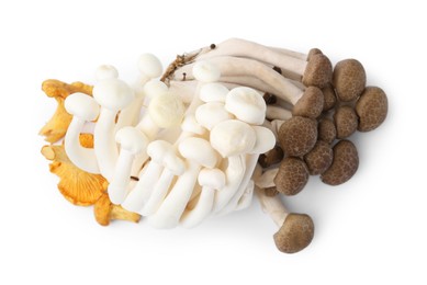 Photo of Pile of different raw mushrooms isolated on white, top view