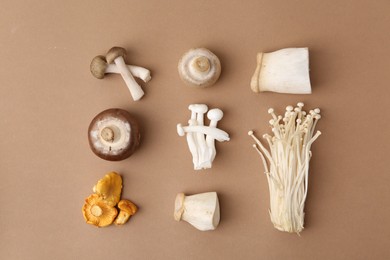 Photo of Different raw mushrooms on beige background, flat lay