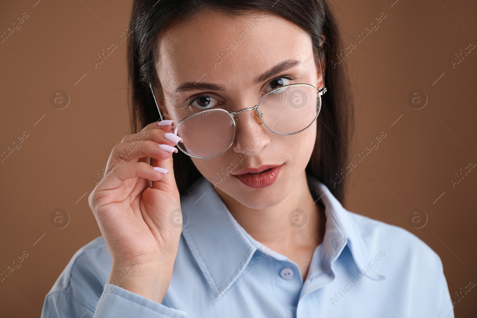Photo of Portrait of confident businesswoman on brown background