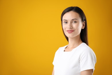 Photo of Portrait of beautiful woman on yellow background. Space for text