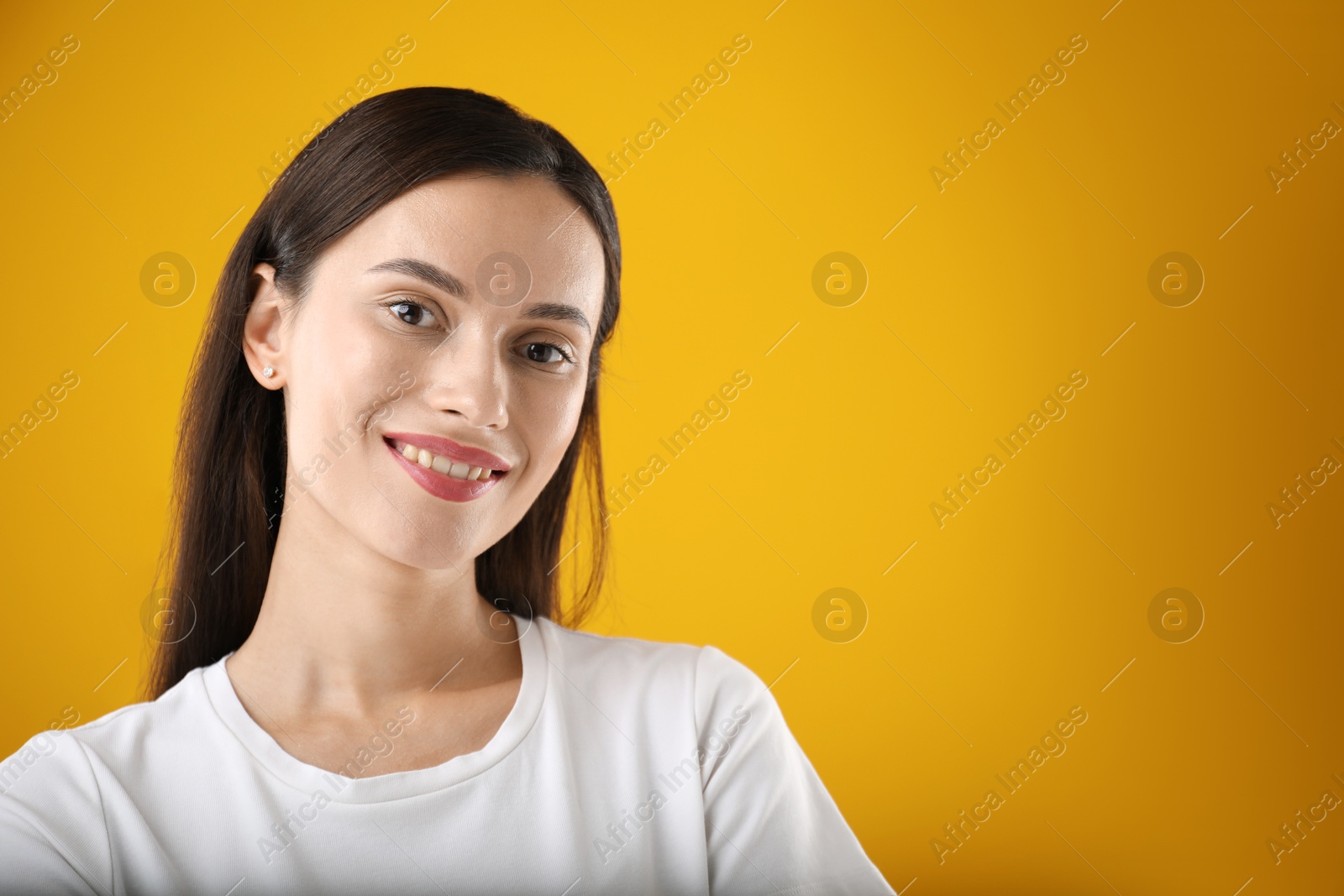 Photo of Portrait of beautiful woman on yellow background. Space for text