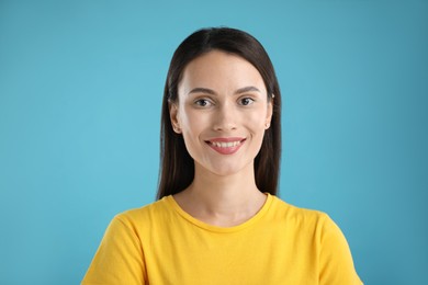 Photo of Portrait of beautiful woman on light blue background