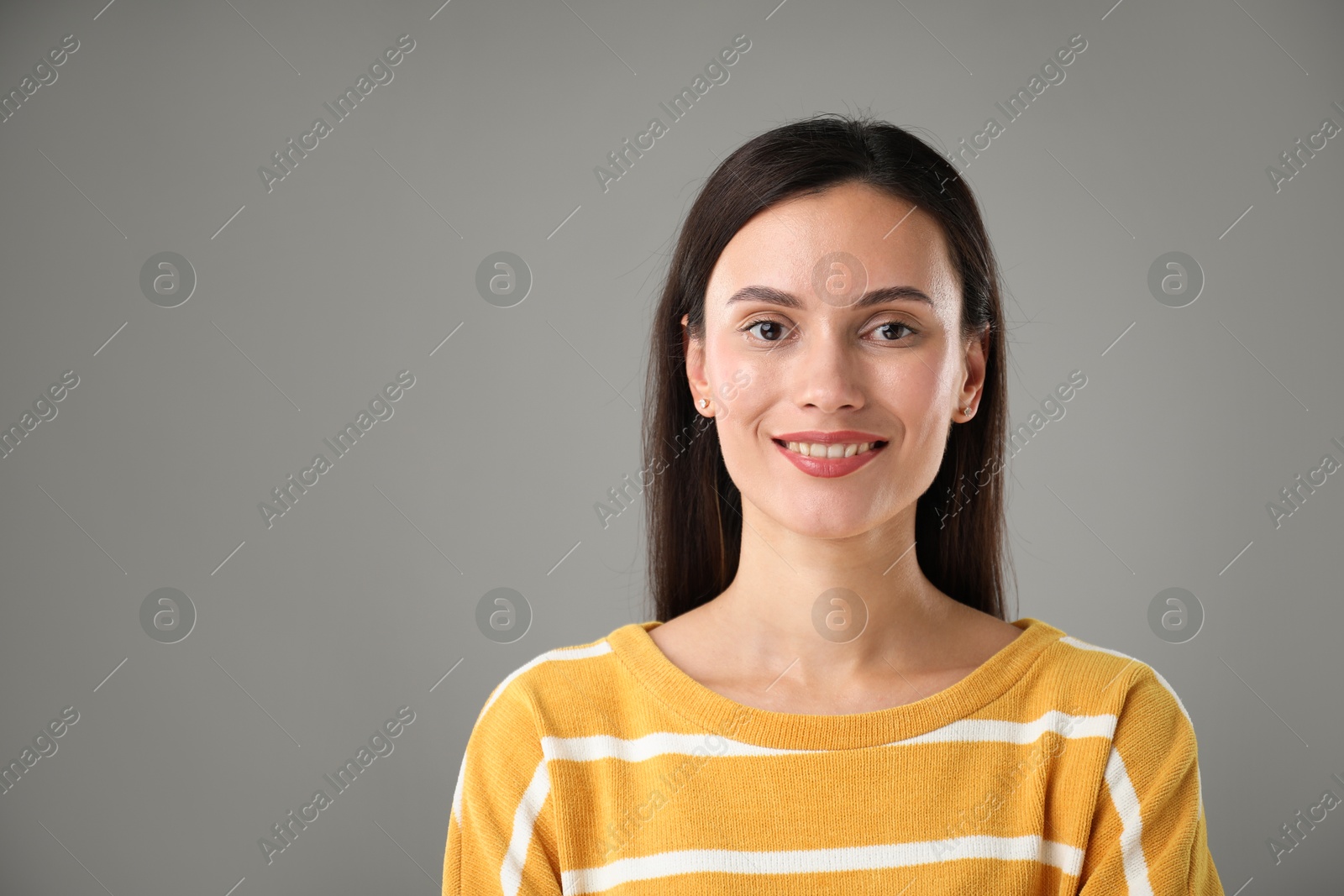 Photo of Portrait of beautiful woman on light grey background. Space for text
